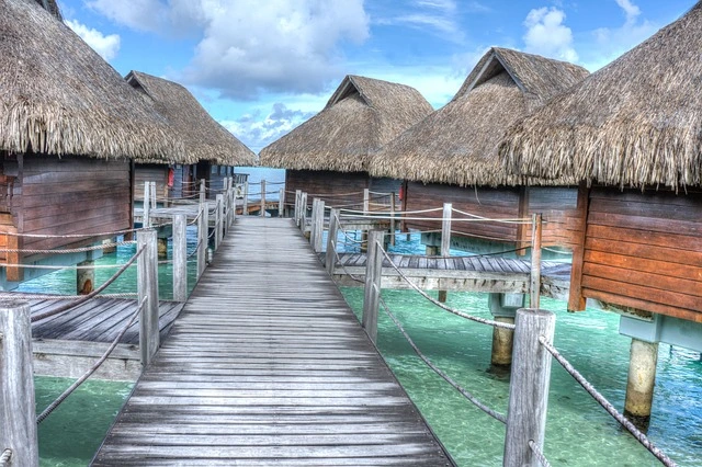 Aerial view of Bora Bora, one of the most beautiful islands, showcasing its turquoise lagoon and overwater bungalows with Mount Otemanu in the background.