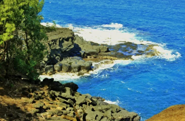 The dramatic cliffs of the Na Pali Coast on Kauai, recognized as one of the most beautiful islands, surrounded by lush greenery and the Pacific Ocean.