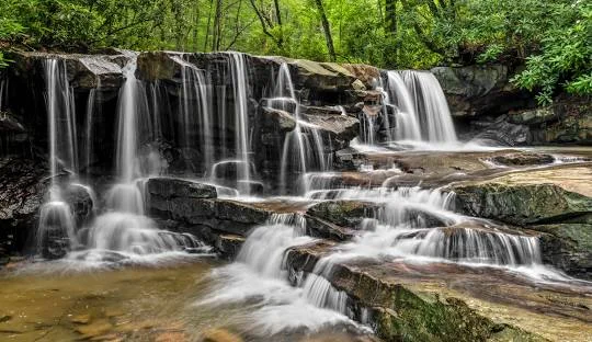 Ohiopyle State Park Waterfall – Picturesque waterfall along the Ferncliff Peninsula Trail at Ohiopyle, an adventurous places to go near me in Pennsylvania for hiking and rafting.