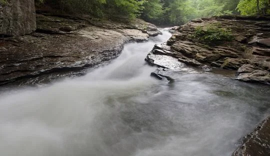 Ohiopyle State Park Waterfall – Picturesque waterfall along the Ferncliff Peninsula Trail at Ohiopyle, an adventurous places to go near me in Pennsylvania for hiking and rafting.